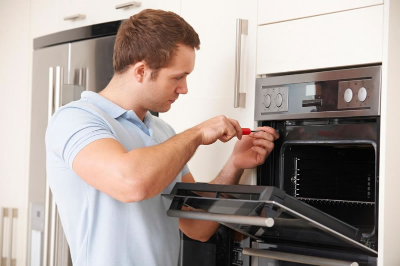 Licensed service provider fixing an oven covered by a home warranty company